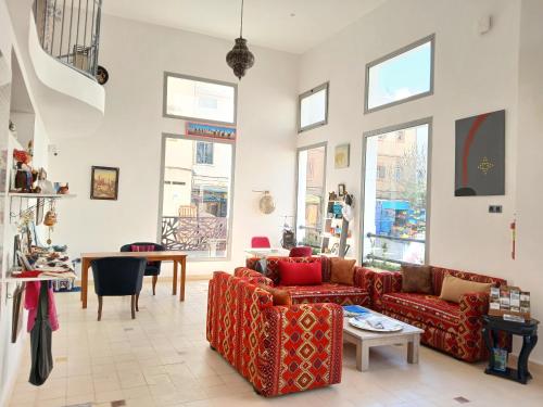 a living room with two couches and a table at Al Bouhaira Abyad Art & Golf in Essaouira