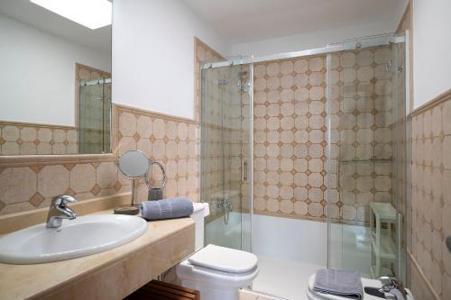 a bathroom with a sink and a toilet and a shower at Ajaches 23 in Puerto Calero