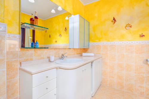 a bathroom with a sink and a mirror at Gli Ulivi Palau - La Zirichelta in Palau