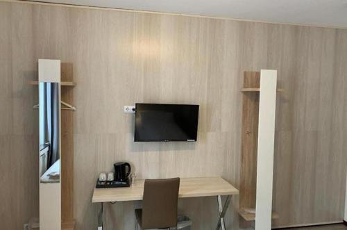 ハノーファーにあるSkyLine Hotel Hannoverのデスク、壁掛けテレビが備わる客室です。