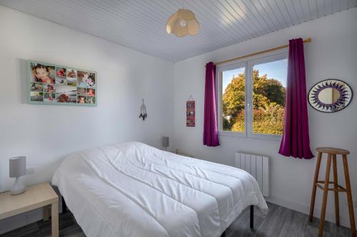 ein Schlafzimmer mit einem weißen Bett und einem Fenster in der Unterkunft Jacuzzi Maison pour 11 au calme plage a 500m in Le Cormier