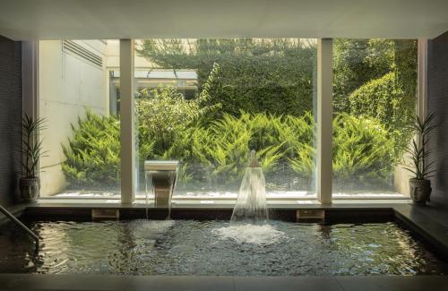 a water fountain in a room with a window at Catalonia Porto in Porto