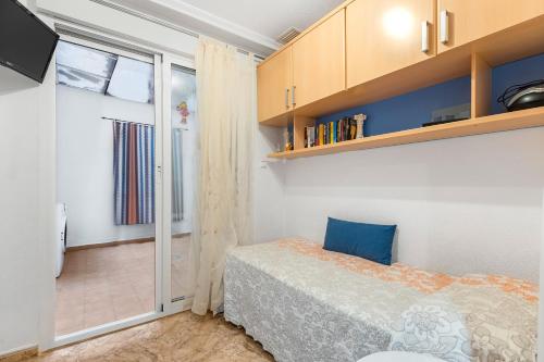 een slaapkamer met een bed en een glazen schuifdeur bij Yovalutres Piscina Privada Torrevi in Torrevieja