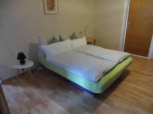 a bed with white pillows and a table in a room at Waldau in Aerzen