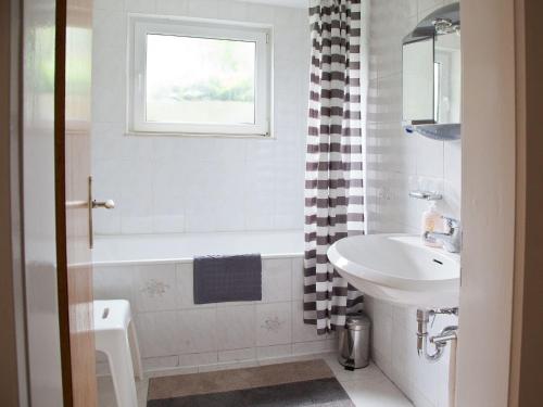a bathroom with a sink and a tub and a toilet at Haus zur Bienenweide in Schömberg
