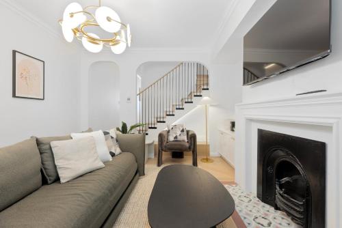 a living room with a couch and a fireplace at City-View Retreat with Tranquil Rooftop Spa in Sydney