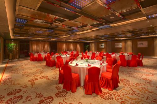 a large banquet hall with red chairs and tables at Sanding New Century Grand Hotel Yiwu in Yiwu