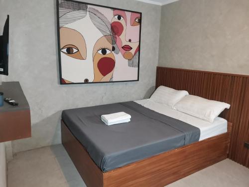 una camera da letto con un letto e un dipinto sul muro di Dancenter Airport Hotel - Grey Hotel a Santol