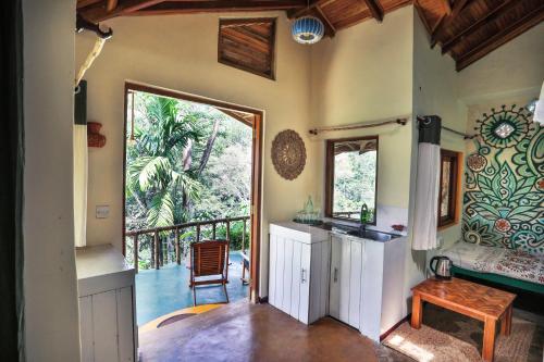 Cette chambre dispose d'une cuisine et d'un balcon avec une table. dans l'établissement Natural Mystic Sanctuary, à Deniyaya