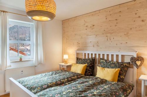 une chambre avec un grand lit avec un mur en bois dans l'établissement Ferienwohnung Fuchsbau, à Oberau