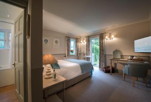 a bedroom with a bed and a desk with a lamp at The Winning Post in Windsor