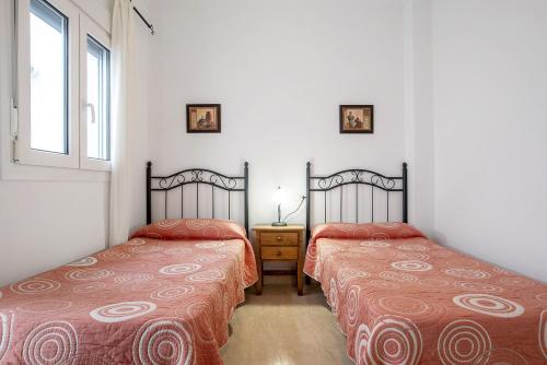two beds sitting next to each other in a room at Aptº Jábega, Familias y Parejas in Conil de la Frontera