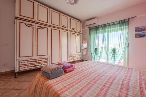 une chambre avec un grand lit et une grande fenêtre dans l'établissement Meizon Sicilia, à Terme Vigliatore