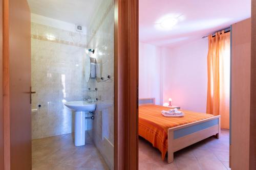 a bathroom with a bed and a shower and a sink at Appartamenti Cavour cod C in Villasimius