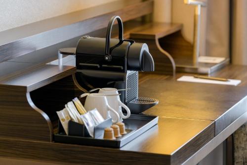 a kitchen counter with a tray with cups and books at Pullman Munich in Munich