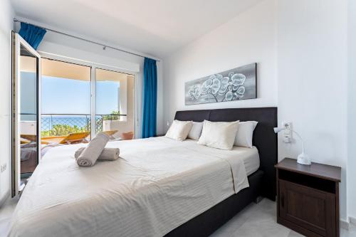 a bedroom with a large bed with a large window at Mi Capricho Calahonda in Mijas