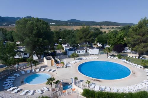 een uitzicht over het zwembad met ligstoelen bij Mobil-home - Le 147 aux Iscles in La Roque-dʼAnthéron