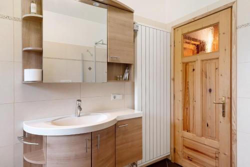 ein Badezimmer mit Waschbecken und Spiegel in der Unterkunft Rotwandterhof Wohnung Fuchsbau in Barbian