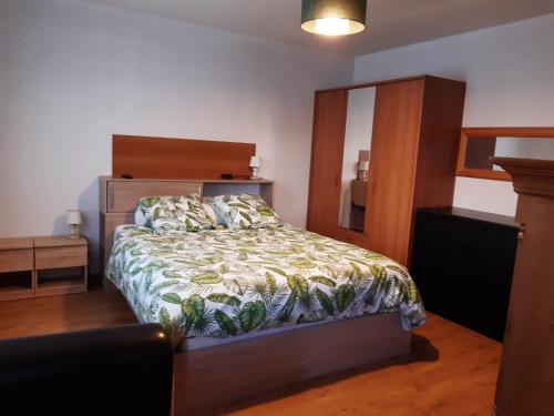 ein Schlafzimmer mit einem Bett mit einem hölzernen Kopfteil in der Unterkunft Maison Escale Dax N78 in Dax