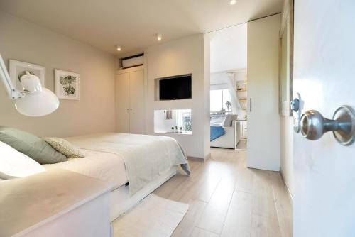 une chambre avec un lit et une télévision à écran plat dans l'établissement Ocean view apartment renovated, à Gavà