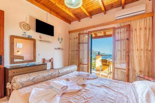 パレオカストリッツアにあるOne bedroom apartment Vasillisのベッドルーム(ベッド1台、鏡、テレビ付)