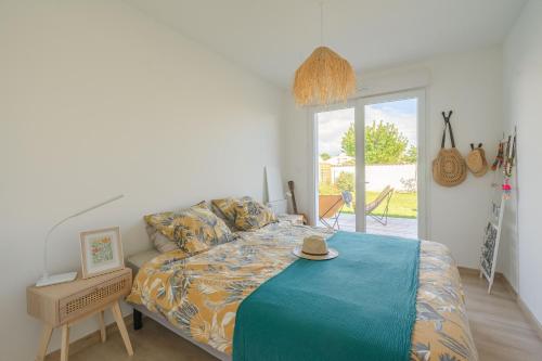 a bedroom with a bed with a hat on it at Jolie maison à Saint-palais in Saint-Palais-sur-Mer