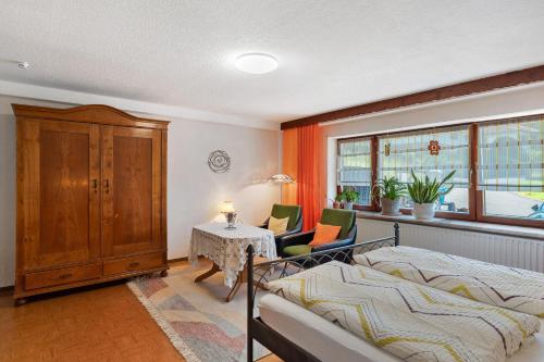 a bedroom with a bed and a table and chairs at Ferienwohnung Grimm in Darstein
