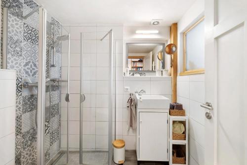 a white bathroom with a shower and a sink at Ferienwohnung Zur Alten Scheune in Balingen