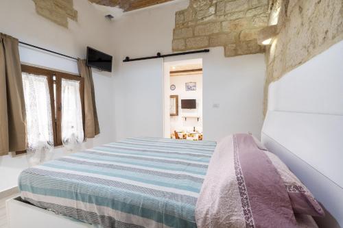 a bedroom with a bed in a white room at Dimora Donna Lucrezia in Mola di Bari