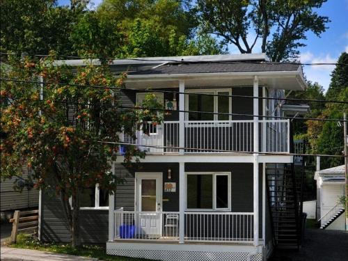 a black and white house with a balcony at Résidence Touristique Chicoutimi in Chicoutimi