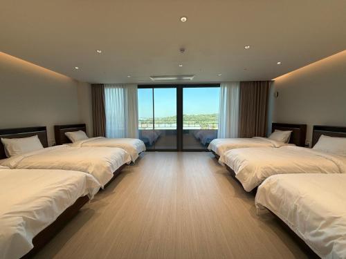 a row of beds in a room with windows at Seohaemaroo Youthhostel in Hwaseong