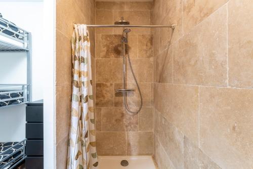 a shower with a shower curtain in a bathroom at Villa Sérénity 10 pers maxi in Mondragon