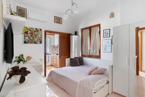 a white bedroom with a bed and a tv at Casatullio - Sant'Angelo d'Ischia in Ischia