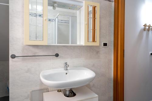 Un baño con un lavabo blanco y un espejo. en A casa di Pietro Quattro, en Leporano