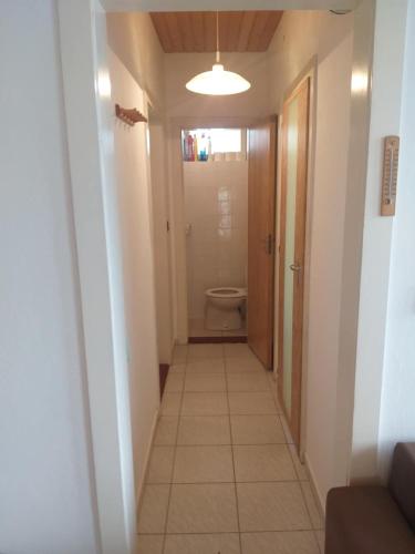 a hallway leading to a bathroom with a toilet at Tomi Vendégház in Kóczántanya