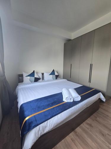 a bedroom with a large bed with blue and white sheets at Jenz-2 Homestay in Bintulu
