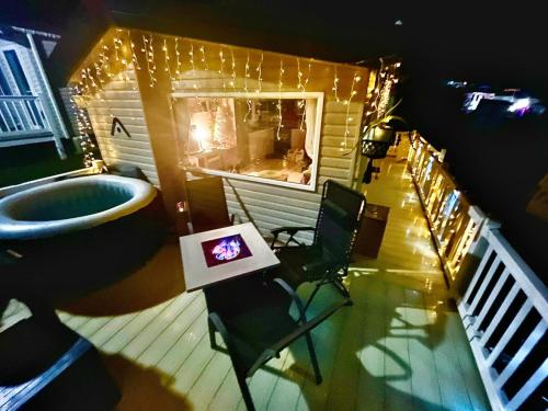 a bathroom with a tub and a table and chairs at Holiday Home with Hot Tub Cornish Country SeaSide in Newquay Bay Resort