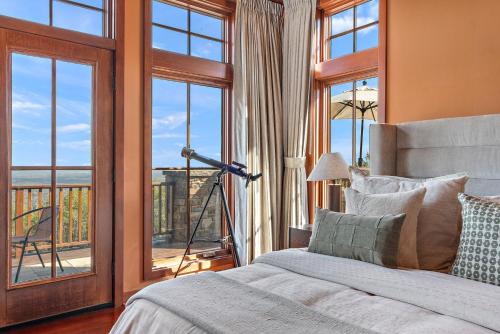 a bedroom with a bed and a window with a view at Pinnacle Pointe by Relaxtay 600 Acre Private Luxury Estate with Spa, Pool, Theater and Lake in High View