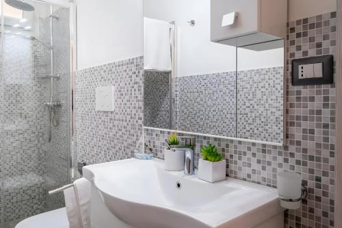 a bathroom with a white sink and a shower at Il Nido sul Mare Sea View in Porto Cesareo