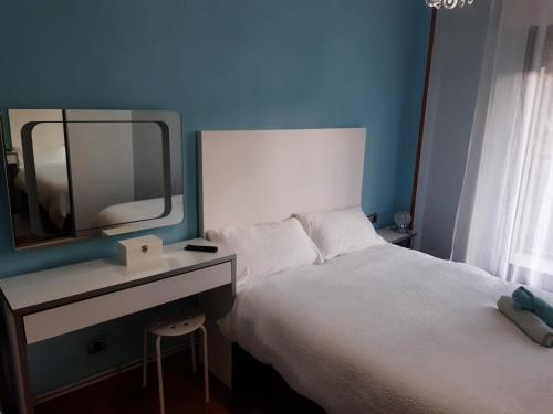 a bedroom with a bed and a desk with a mirror at Piso en Donostia AÑORGA in Donostia-San Sebastián