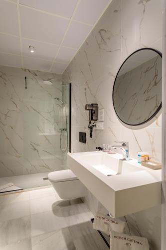 a bathroom with a sink and a toilet and a mirror at Luces de Catedral in Alicante