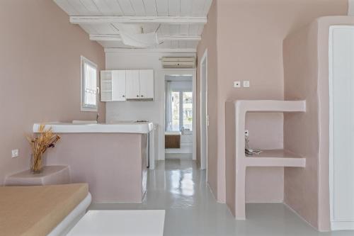 a white kitchen with a sink and a toilet at Ninemia Suites Tinos Grand 204 in Kionia