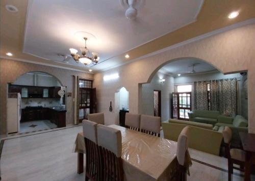 a dining room with a table and a living room at 2BHK Central Gurgaon in Gurgaon