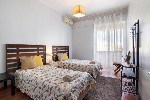 une chambre avec deux lits et une fenêtre dans l'établissement Blue Ocean Rooftop, à Olhão