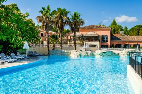 a swimming pool with a waterfall in a resort at Domaine de Fayence in Fayence