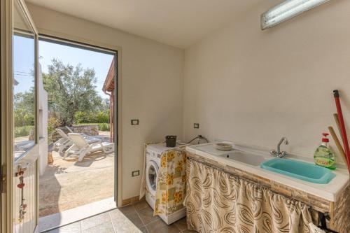 a bathroom with a sink and a washing machine at Villa Elena in Marina di Pescoluse