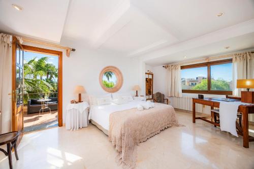 a white bedroom with a bed and a desk at Can Gual Inca in Inca