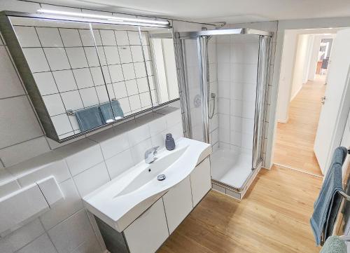 a white bathroom with a sink and a shower at Valley Chalet mit Sauna u Bergblick in Bestwig