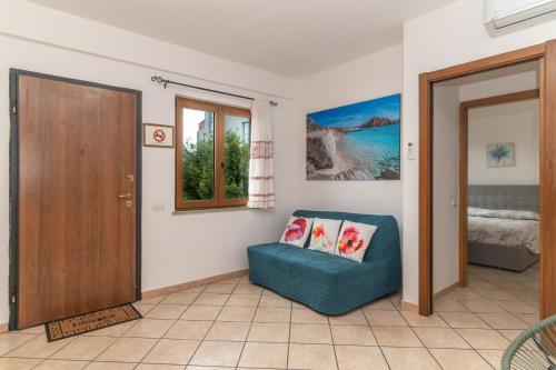 Guest House in the Center of Olbia في أولبيا: غرفة بها كرسي ازرق وباب