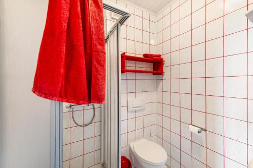 a bathroom with a red towel hanging over a toilet at Möve Aba Appartment 33 in Rerik